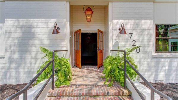 Entrance to 720 Magnolia Road: white brick, open wooden doors and ferns either side of the brick steps